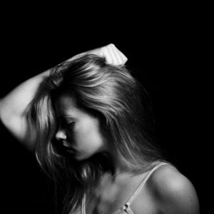 a black and white photo of a woman with her hand on her head